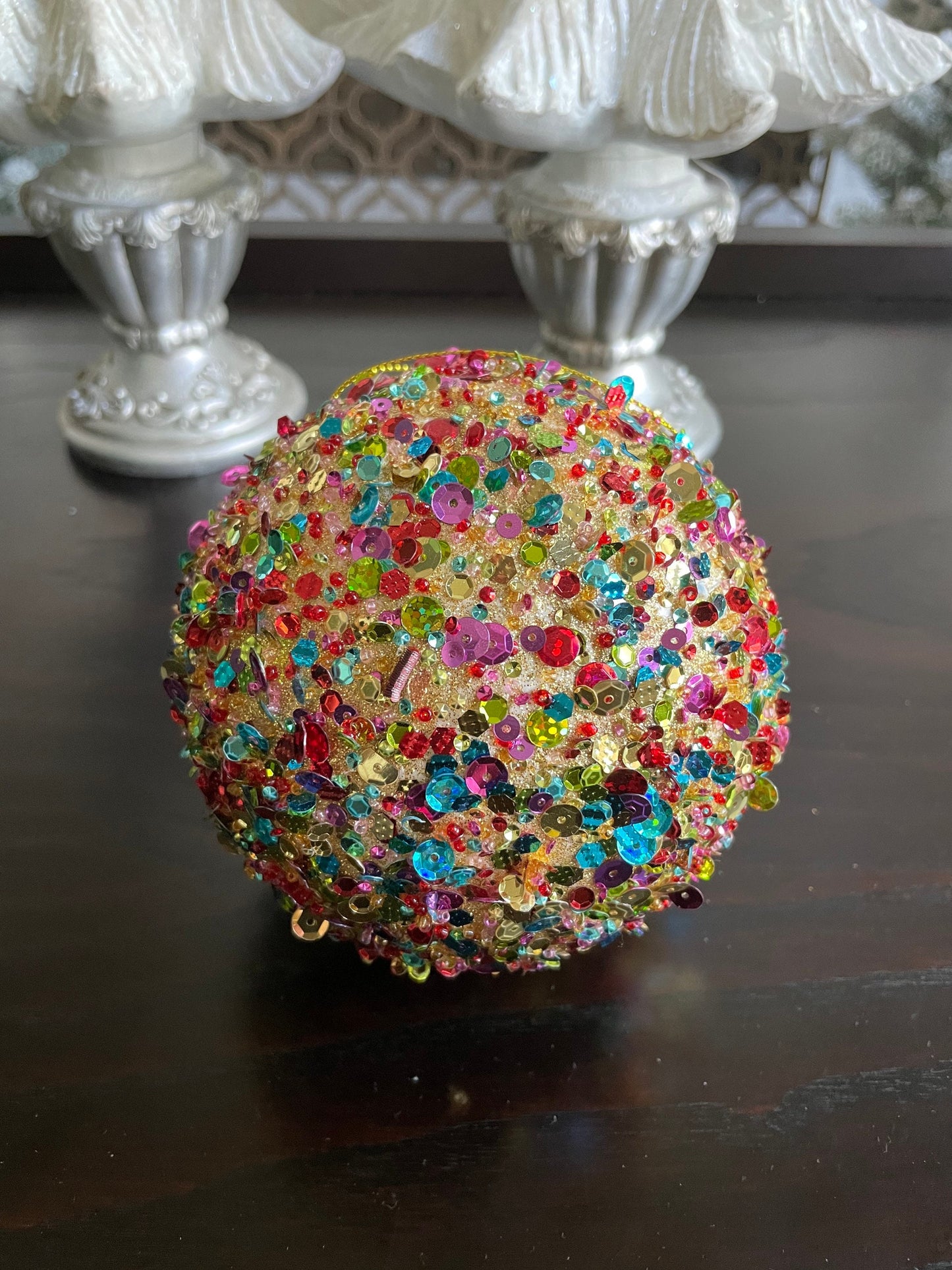 4.5” sequin ball ornament, red main color with multiple secondary colors.