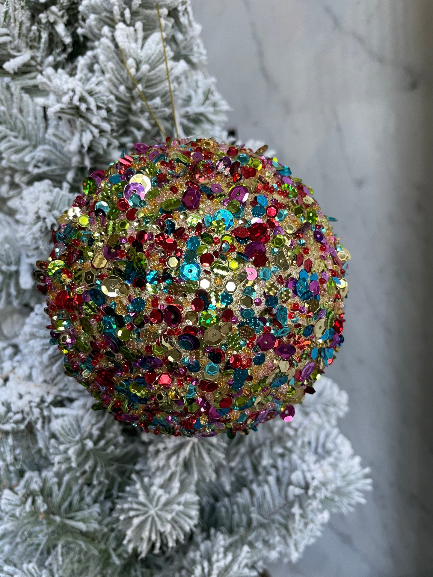 4.5” sequin ball ornament, red main color with multiple secondary colors.