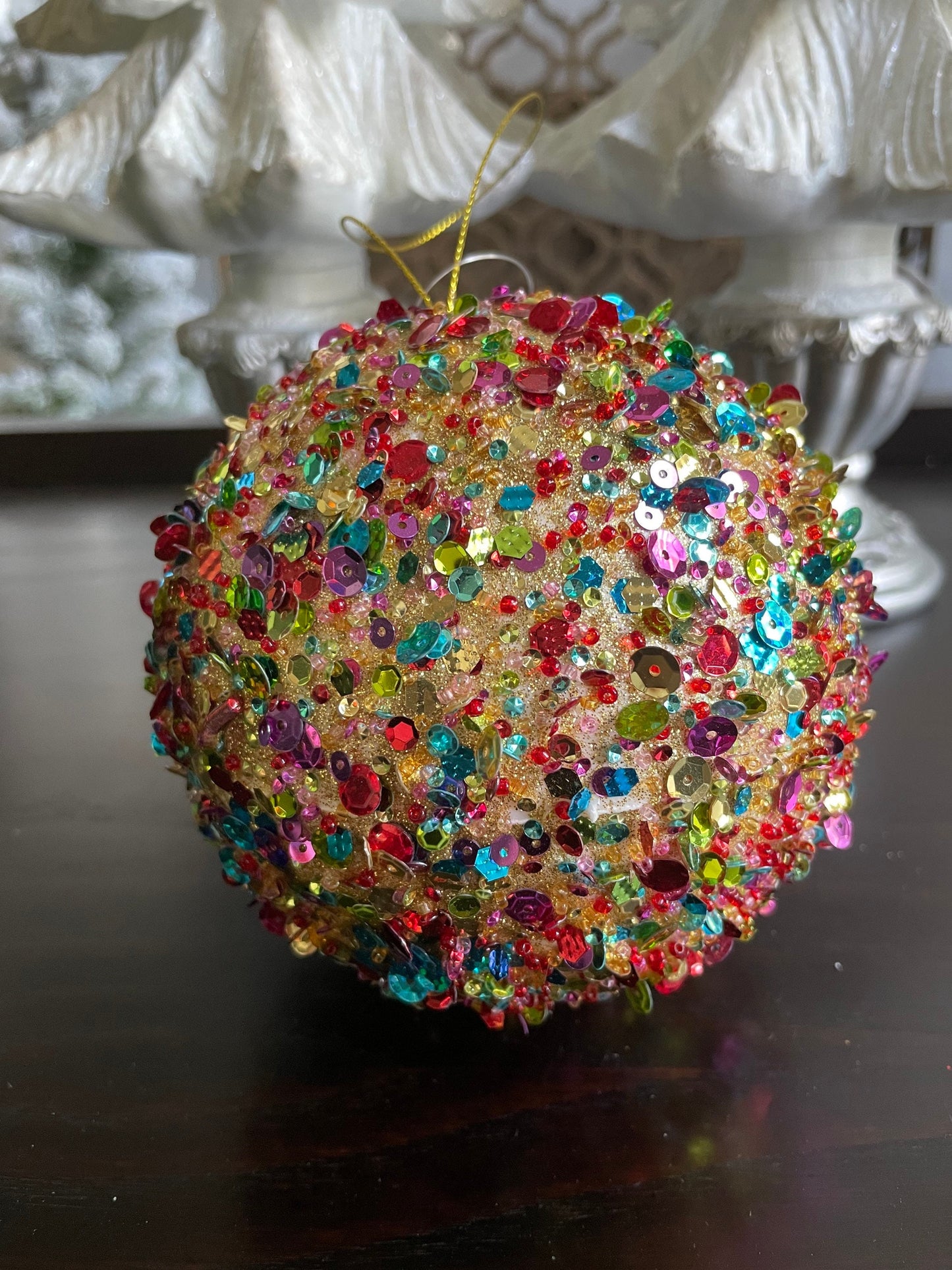 4.5” sequin ball ornament, red main color with multiple secondary colors.