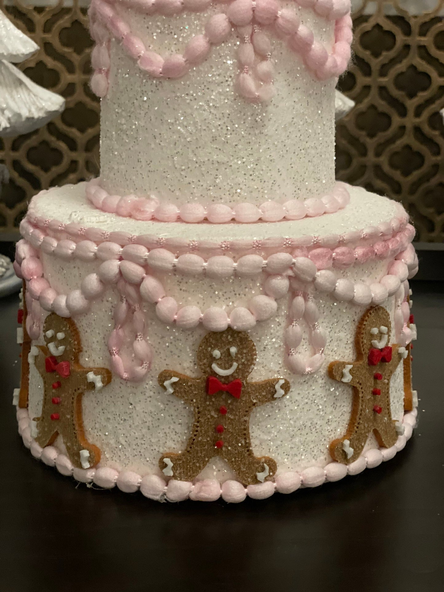 14”h x 8”w gingerbread Christmas icing pink cake.