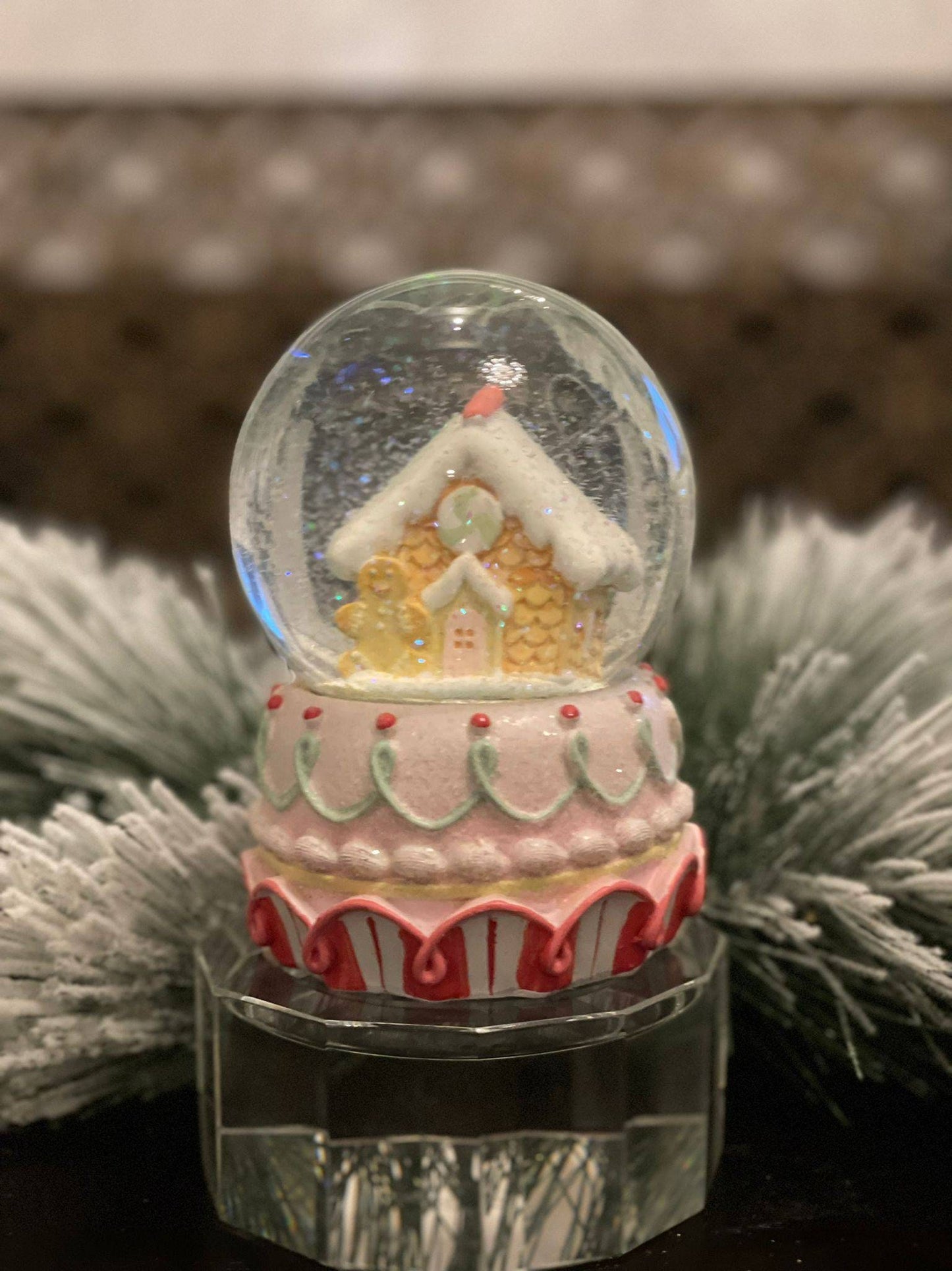 6" Resin gingerbread house water globe. Pastel colors.