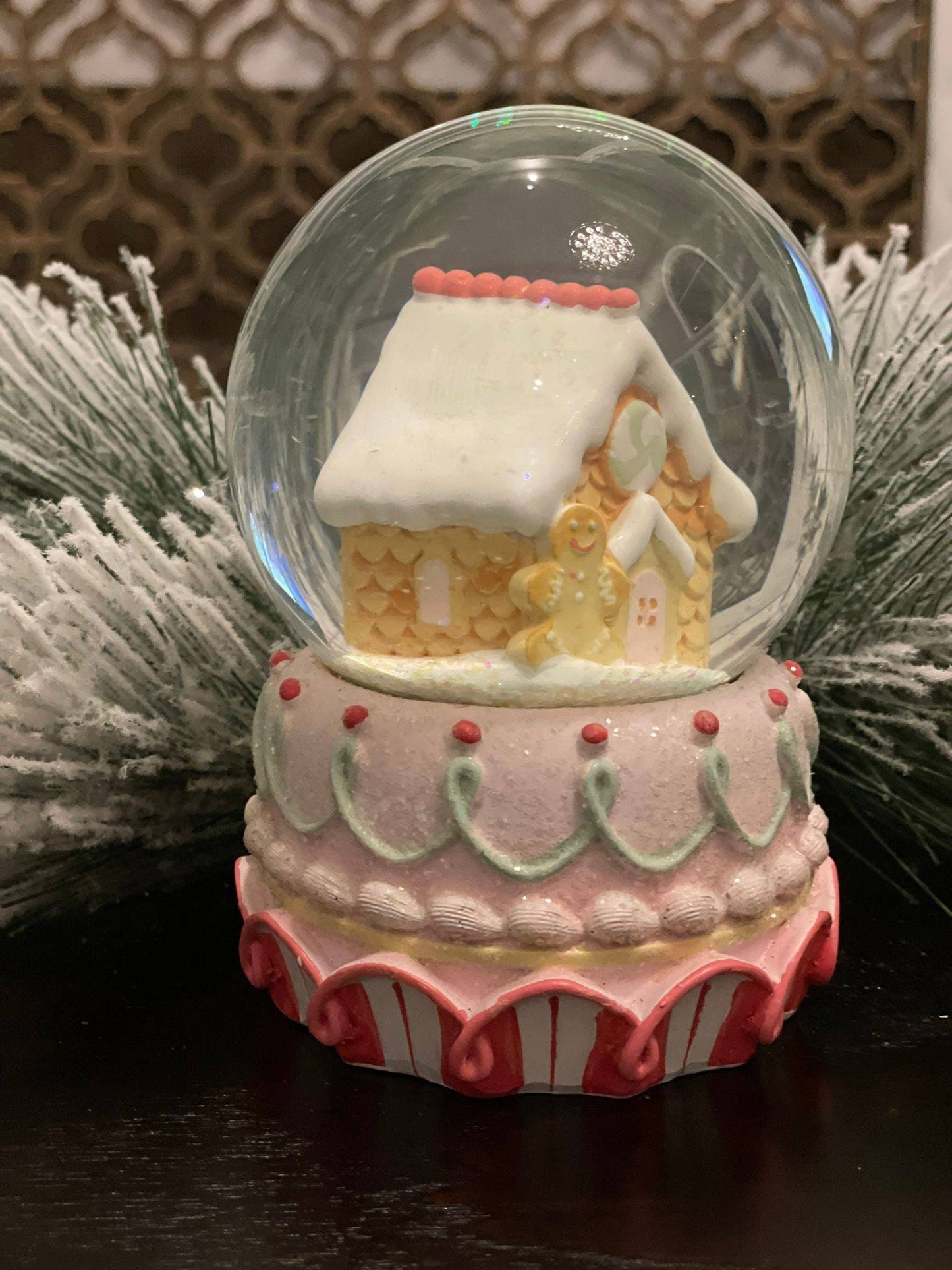 6" Resin gingerbread house water globe. Pastel colors.