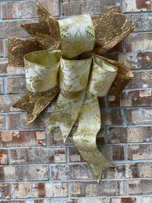 17”approx. diameter Bow antique gold and gold ribbon with 3 streamers the longest is 20” long from center of bow.