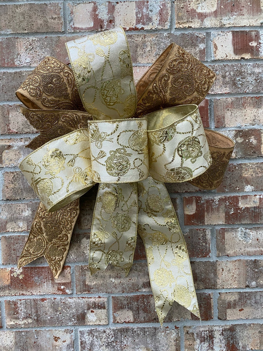 17”approx. diameter Bow antique gold and gold ribbon with 3 streamers the longest is 15” long from center of bow.