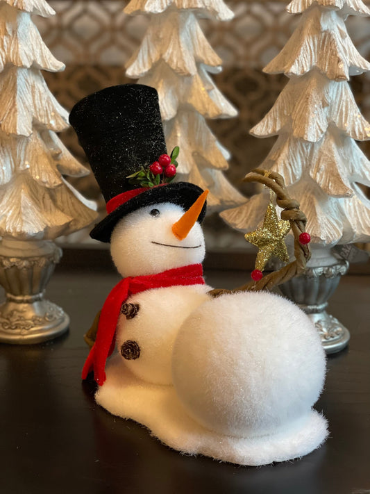 9.75” frosted snowman laying with star tabletop ornament