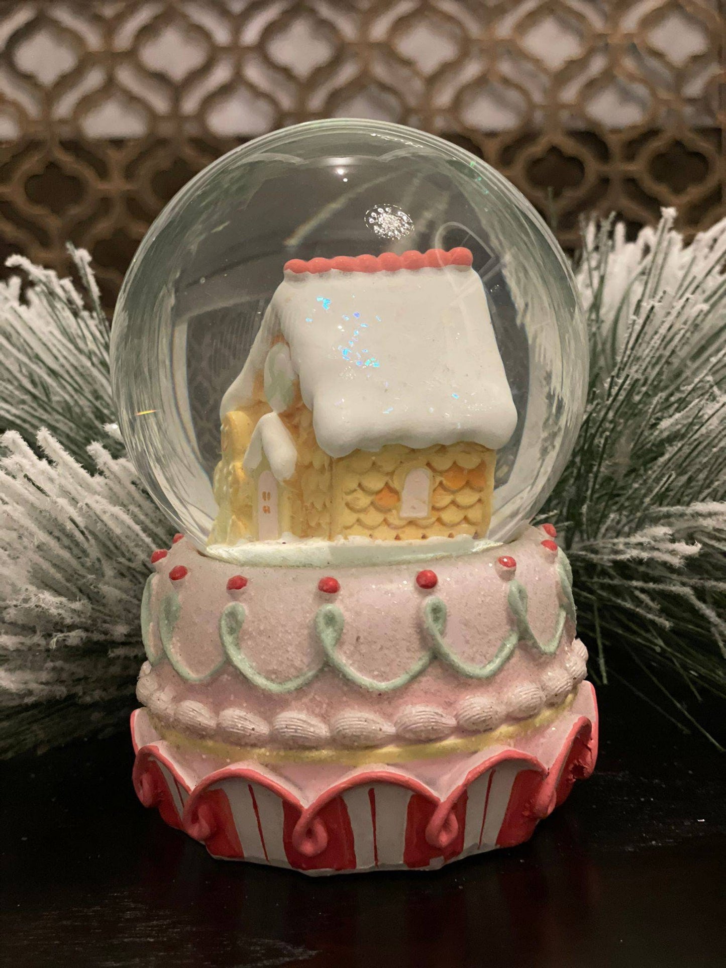 6" Resin gingerbread house water globe. Pastel colors.