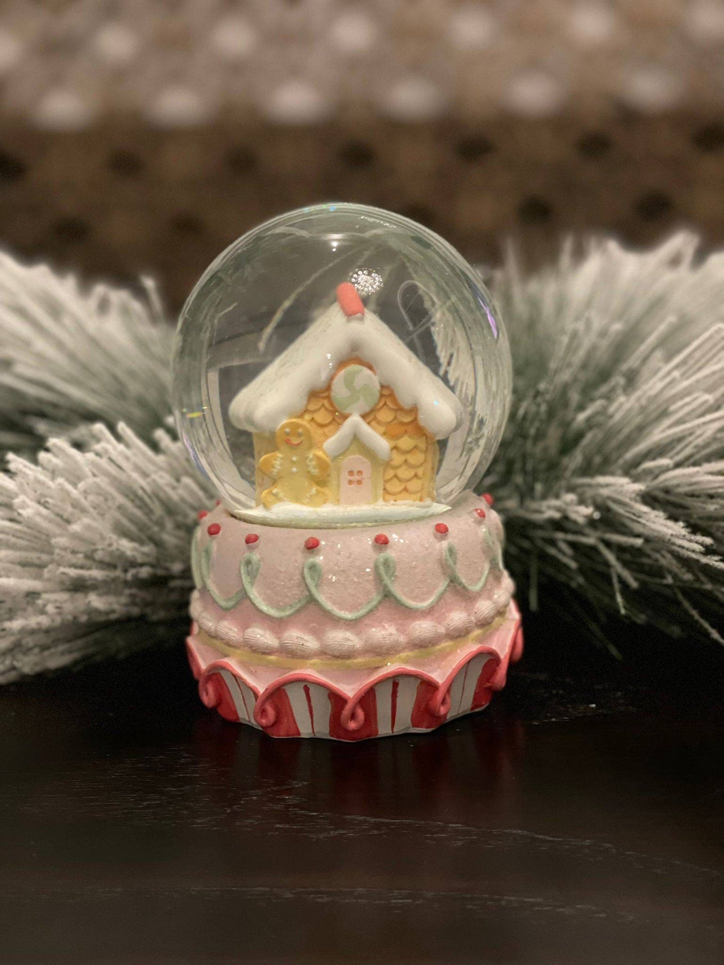 6" Resin gingerbread house water globe. Pastel colors.
