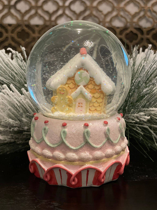6" Resin gingerbread house water globe. Pastel colors.