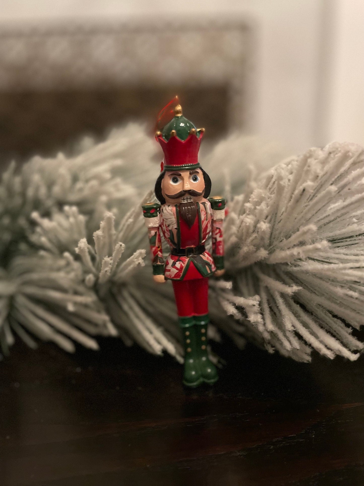 6” Poinsettia nutcracker ornament. Resin.