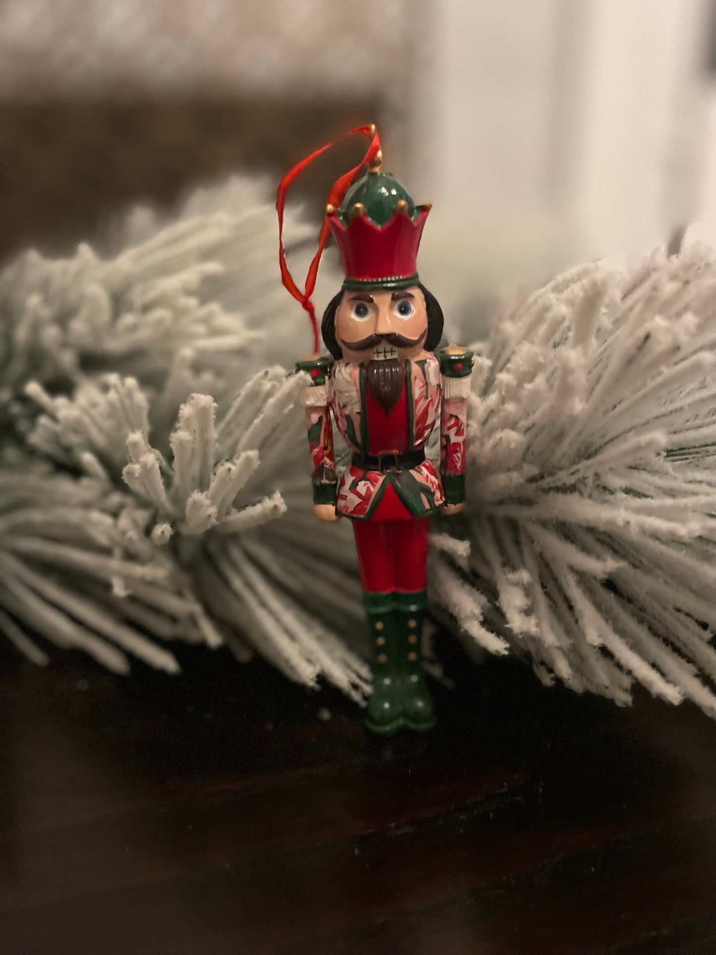 6” Poinsettia nutcracker ornament. Resin.