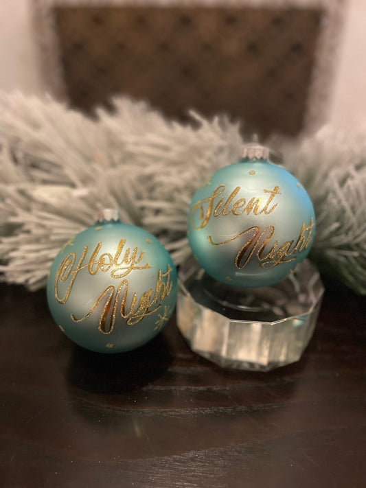 Set of 2. 4” aqua gold silent night and holly night glass ball ornaments. Set of 2.
